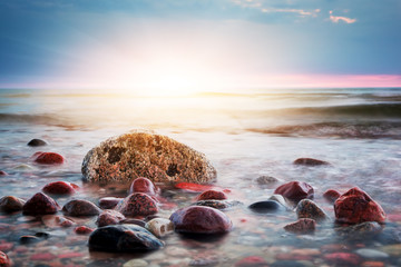 Dramatic colorful sunset on a rocky beach. Baltic sea