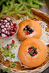 plate of homemade buns with berries, served on old wooden table