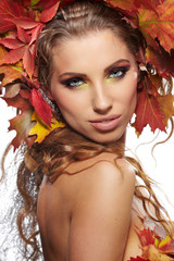 Autumn woman dressed in red leaves