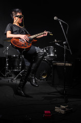 Young woman playing guitar during the concert