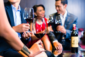 Asian Friends drinking wine in bar
