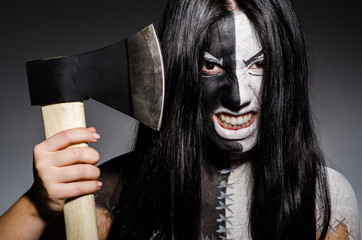 Scary woman with metal axe in halloween concept