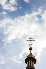 Fototapeta na wymiar The cross of the orthodox Christian church against the cloudy sk