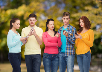 group of serious teenagers with smartphones