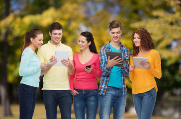 group of teenagers with smartphones and tablet pc