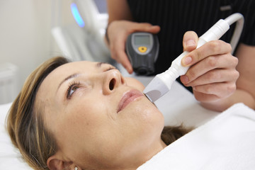 Obraz na płótnie Canvas Beautician Carrying Out Ultrasound Skin Rejuvenation Treatment