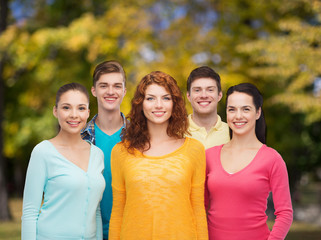 group of smiling teenagers over green park