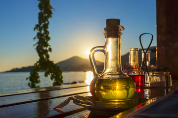 Obraz na płótnie Canvas bottle with olive oil on a background of sea sunset