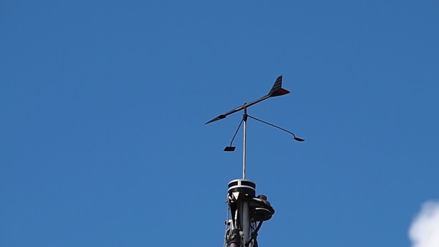Marine weather wind vane on top of a sail boat mast