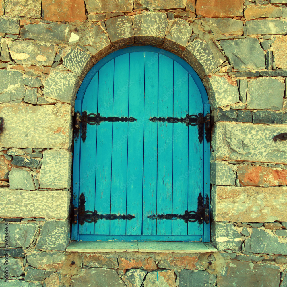 Sticker vintage window with blue close shutters, crete, greece.