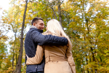 smiling couple hugging in autumn park