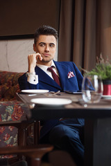 Successful businessman sitting at the table of the restaurant