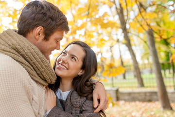 Fototapeta premium smiling couple hugging in autumn park