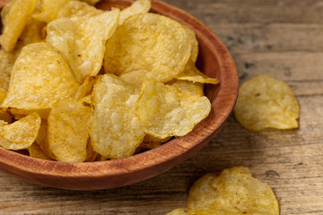 Crispy potato chips on wooden background