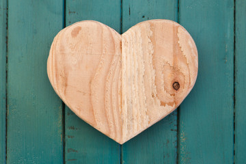 Love Valentines wooden heart on turquoise painted background