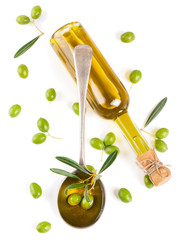 View from above of a olive oil in bottle, in a spoon and raw oli