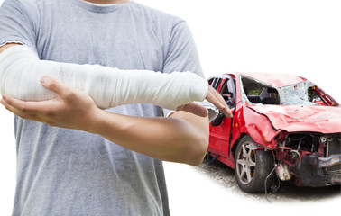 closeup of bandaged arm with blue wrecked car
