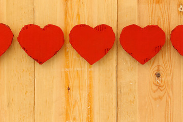 Love Valentines red cardboard hearts on rough pine background