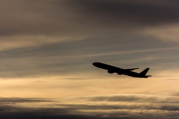 Fototapeta na wymiar Silhouette airplane in the sky