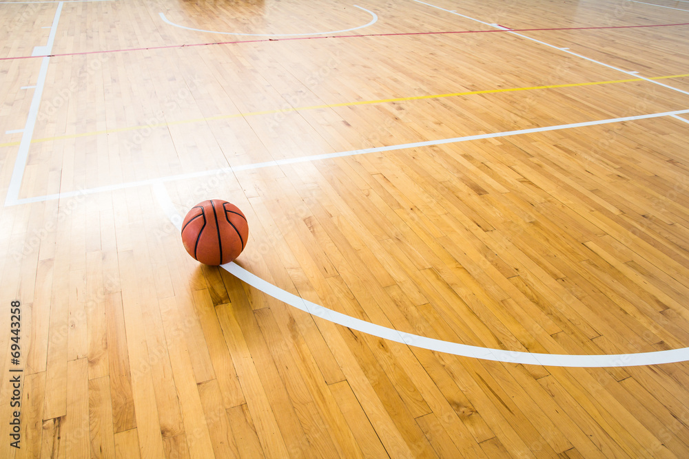 Wall mural Basketball ball over floor in the gym