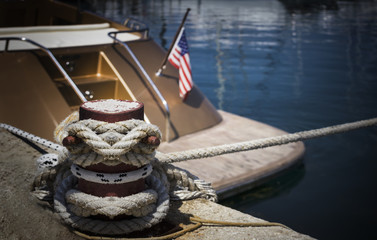 Mooring bollard with nautical rope knotted on it.