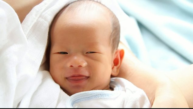 Asian newborn baby smiling