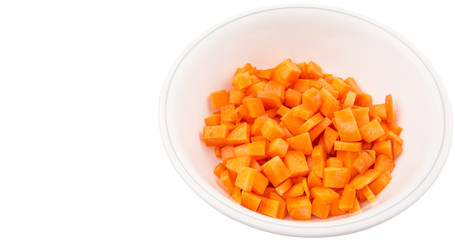 Chopped carrot in a bowl over white background