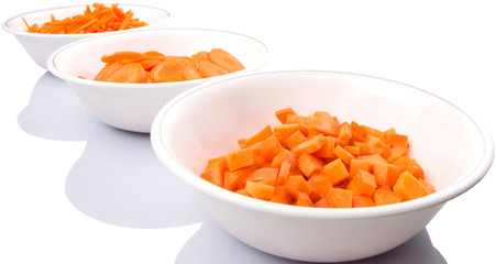 Different style of chopped carrots in white bowls