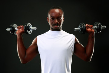 Naklejka na ściany i meble handsome african sports man over black background