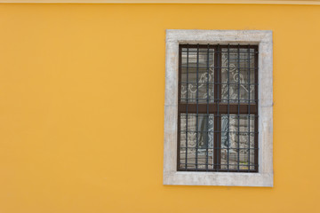 Yellow wall with wrought iron window