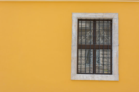 Yellow wall with wrought iron window