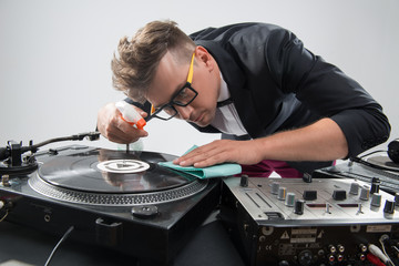 DJ in tuxedo cleaning his turntable