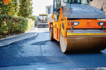 Tandem vibration roller compactor working on asphalt pavement