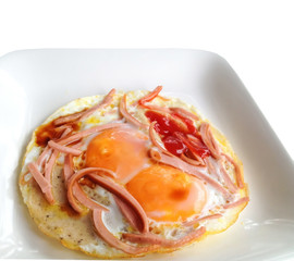fried eggs and sausage sliced on white plate isolated on white b