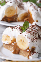 Piece of banana cake with cream close up on the table