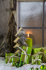 Natural wooden christmas decoration with candles and green prese