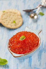 Red caviar in fish-shape bowl with crackers