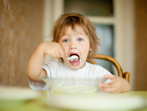  child eats dairy  with spoon