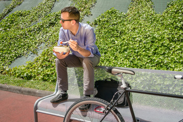 Young business man eating at lunch break outdoors