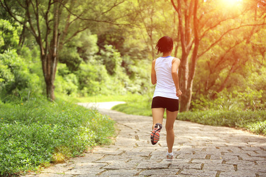 fitness woman runner running on forest trail