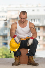 Tired Builder Resting On Brick