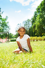Portrait of black girl in park sitting on lawn