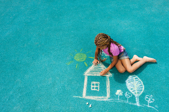 Little black girl drawing chalk house image