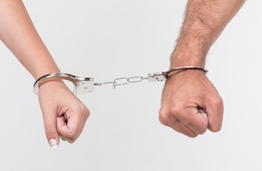 Man and woman's hands handcuffed together