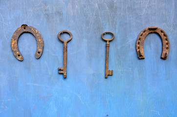 rusty ancient key and horseshoe hang on wooden barn wall