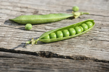 fresh pea pods onwooden boards