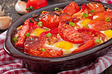 Baked tomatoes with garlic and eggs decorated with green onions