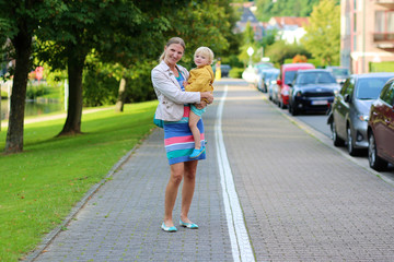 Happy young mother and daughter outdoors in the city