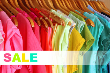 Concept of discount. Colorful clothes on hangers in wardrobe