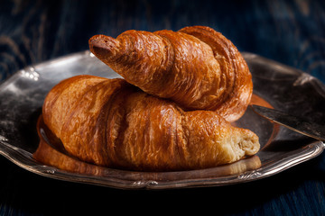 Croissants with butter and a glass of milk